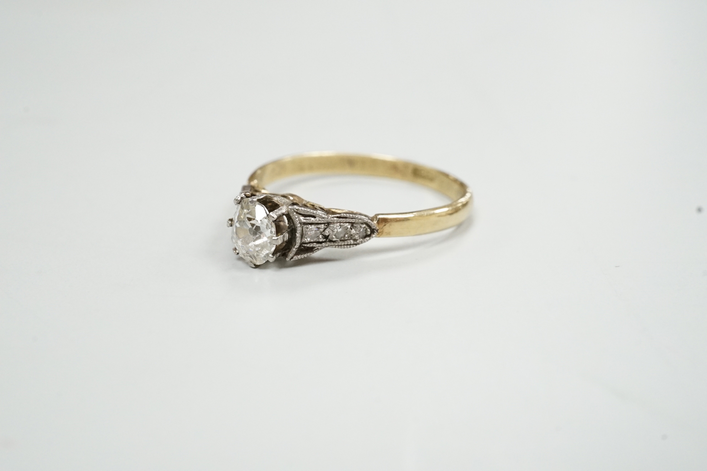 An 18ct and single stone diamond set ring, with diamond set shoulders, size N/O, gross weight 2.2 grams.